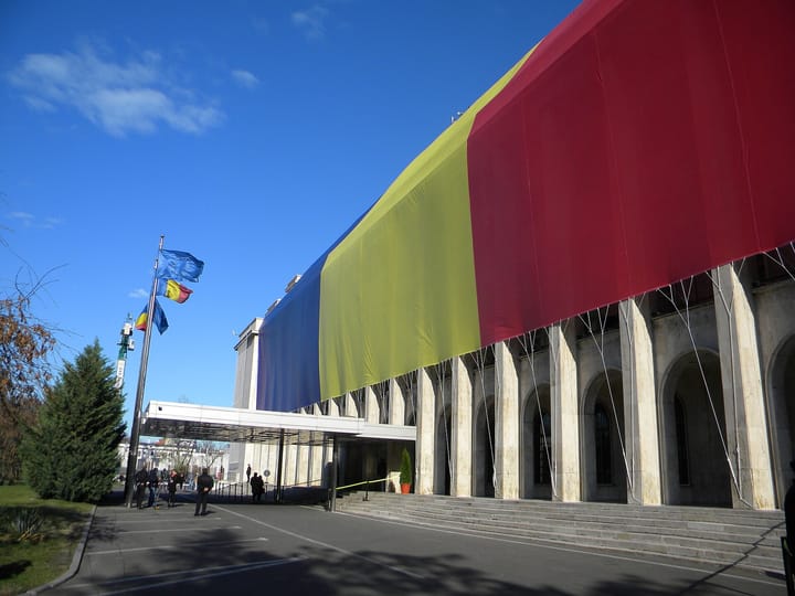Palatul Victoria din București, sediul Guvernului României, cu un drapel tricolor uriaș pe fațadă